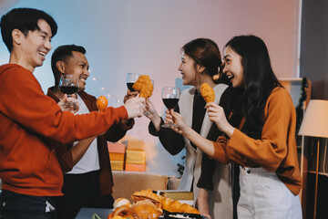 Group of young Asian man and women as friends having fun at a New Year's celebration, holding gift...
