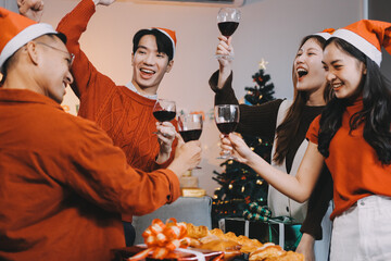 Group of young Asian man and women as friends having fun at a New Year's celebration, holding gift...