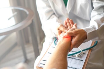 Doctor holds and examines a patient's wrist, focusing on providing accurate diagnosis and...