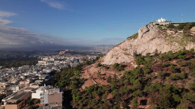 Lycabettus Hill Park in Athens, Greece with Acropolis in background, 4K drone shot.