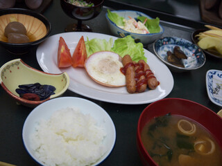Japanese ryokan western style breakfast set with fried egg and sausages mixed with traditional meals