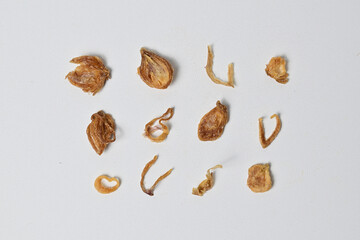 Collection of Indonesian Bawang Goreng or fried red onions isolated on white background with clipping path. Crispy onion fries or shallots are fried to a golden brown color. Fried onions texture.