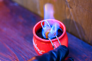 Eine Tasse Feuerzangenbowle mit brennendem Zucker