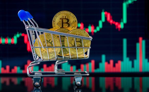 Bitcoin and cryptocurrency investment concept. Gold Bitcoin crypto coins in a shopping cart in front of a Bitcoin chart