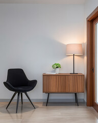 Modern living space showcasing a stylish chair lamp and wooden cabinet in bright decor