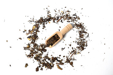 Top view of dried tea leaves on little wooden scoop. isolated on white background. Scattered dried tea leaves close up.
