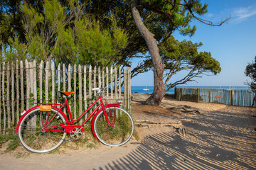 Vieux vélo rouge au bords des plages de Bretagne en France.