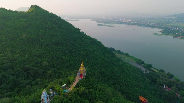 Aerial fly golden Buddhist temple River jungle mountain of Kanchanaburi Thailand
