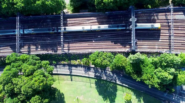 Drone aerial landscape of passenger train on railway tracks line in Sydney city Central Station park Australia transport metro urban carriages CBD Surry Hills