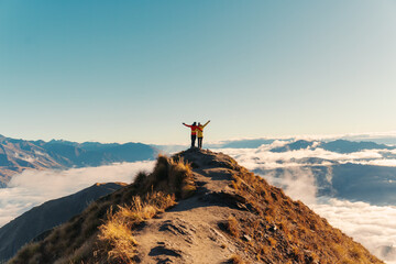 Couple hiker standing on Roys Peak mountain with foggy in the morning at New Zealand