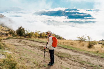 Female tourist hiking on Roys Peak summit mountain with foggy in the morning at New Zealand