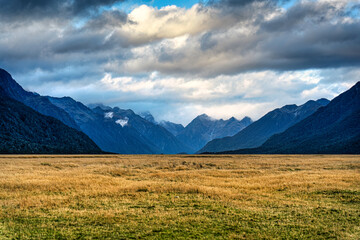 Scenery of Eglinton Valley with mountain range and meadow from Milford Road in autumn