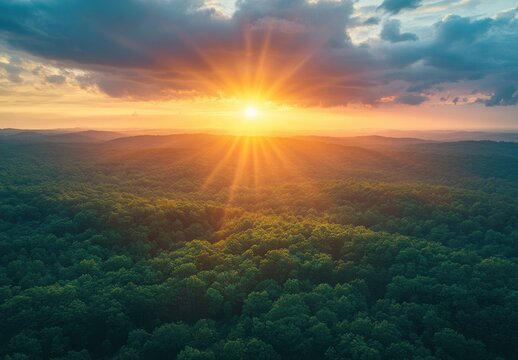 Breathtaking Sunrise Over Lush Green Forests with Vibrant Sunrays Illuminating the Clouds and Landscape, Captured in a Serene Natural Setting