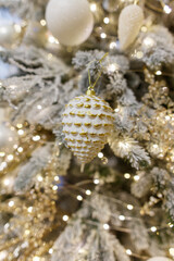 A tree with a gold and white ornament hanging from it