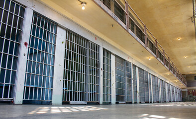 A prison cell block with many cells and bars