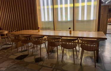 A long wooden table with many chairs around it