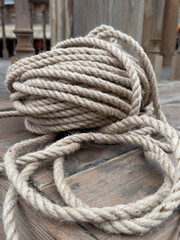 A long rope is laying on a wooden surface