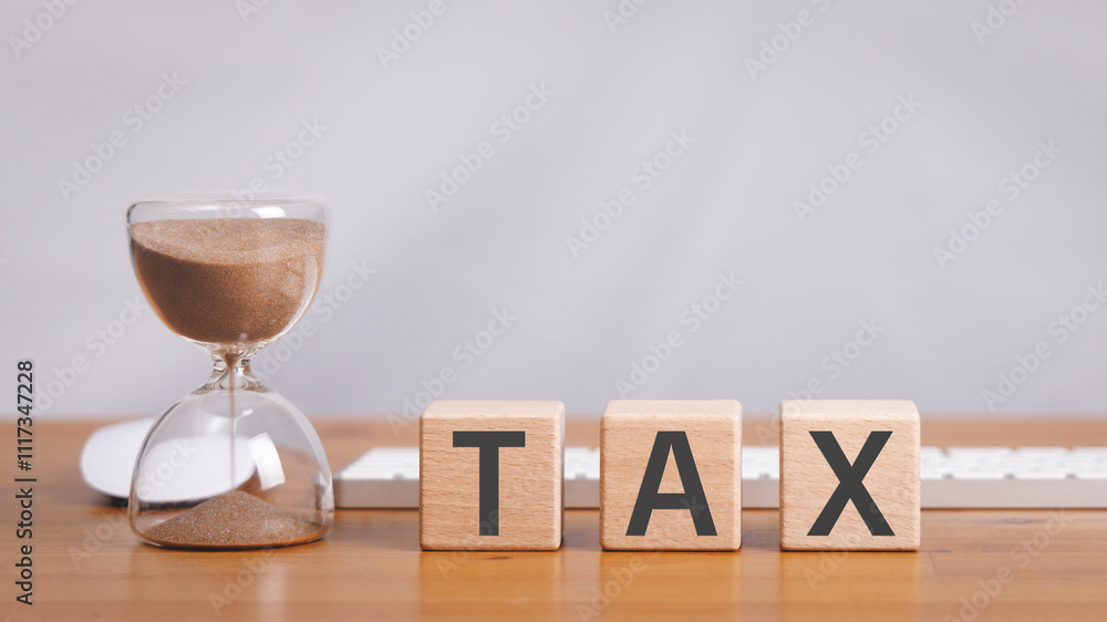 Poster wooden cube block with tax text on wooden table with hourglass, computer mouse and keyboard in white