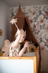 little girl in a fairy-tale children's room sitting on the bed