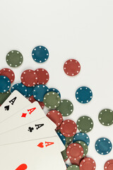 Top view of playing cards, poker chips on white background. Four aces cards, board game, poker. Copy space, flat lay.