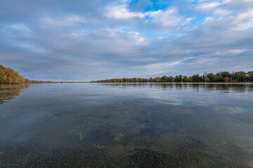 A calm lake with trees in the background