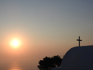 Über einer nebligen Bucht geht die Sonne unter, Monolithos Kapelle