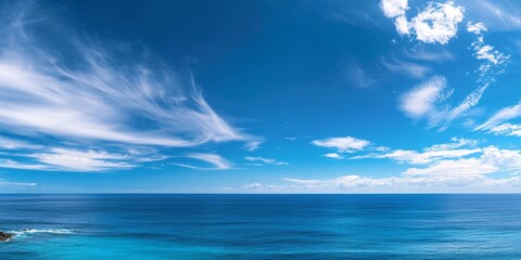 Obraz premium Stunning blue ocean landscape paired with a vibrant blue sky creates a serene and picturesque scene. The blue ocean landscape reflects tranquility and beauty under the expansive blue sky.