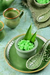 Tape Ijo is a traditional Indonesian dessert made from fermented glutinous rice, with a sweet and tangy flavor, served with green-colored pandan leaves for a refreshing and unique taste.