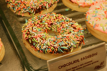 A show case of delicious donuts of irresistible appearance in a donuts shop. Pastry, dessert, sweet.