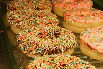 A show case of delicious donuts of irresistible appearance in a donuts shop. Pastry, dessert, sweet.
