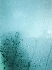 A blue background with water droplets on it. The water droplets are scattered all over the background, creating a sense of movement and fluidity.