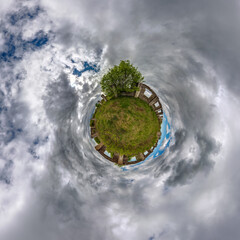 tiny planet in blue sky with clouds of old abandoned ruined church. Transformation of spherical 360...