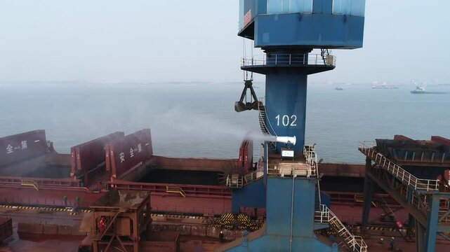 Loading arm transferring cargo into a giant cargo ship