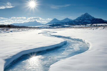 A serene winter landscape featuring a winding river through snow with mountains in the background.