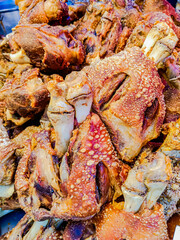 Crispy fried pork leg on tray at market.