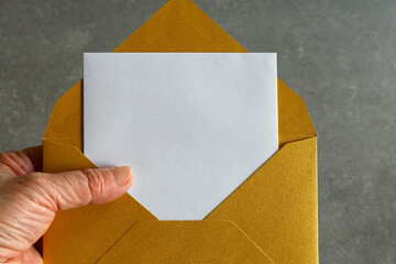 A close-up of a gold envelope holding a white card. The composition symbolizes love and...