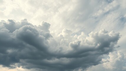 Obraz premium A dramatic view of white and gray cumulus clouds forming a captivating pattern in the sky