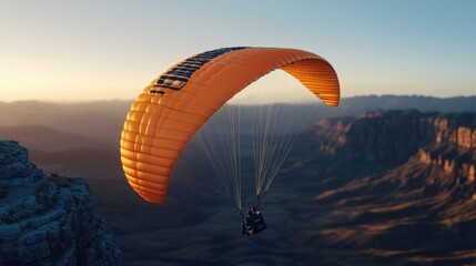 Obraz premium A Paraglider Soars Over Breathtaking Landscape at Sunset with Vibrant Orange Canopy and Majestic Mountains