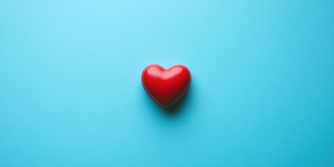 Fototapeta premium A red heart icon on a blue surface, symbolizing love or affection.