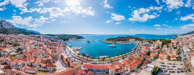 Aerial view of Makarska city center with its vibrant waterfront, yachts, traditional architecture,...