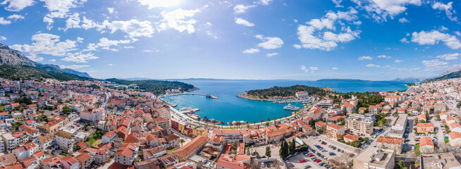 Naklejka premium Aerial view of Makarska city center with its vibrant waterfront, yachts, traditional architecture, and the stunning Adriatic Sea coastline