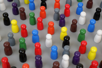 Many different colored wooden people figures on gray background. Society concept.