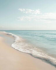 Fototapeta premium Serene beach scene with gentle waves and soft sandy shore.