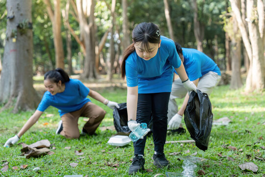 Family Leading Park Cleanup with Volunteers for a Greener Future - Powered by Adobe