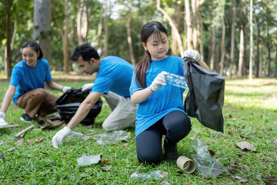 Family Volunteering Together in Park Collecting Litter and Promoting Environmental Awareness