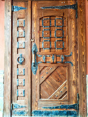 Intricately designed wooden door with metal accents in a rustic setting