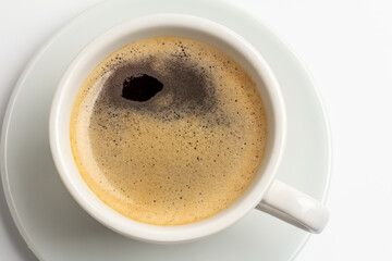 White porcelain cup of black coffee on the white background