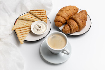 Homemade grilled toasts for breakfast with croissants and a cup of black coffee.
