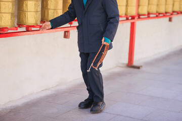 Tibet,China - December 04,2024,One senior man  Spin the Tibetan Prayer Wheels in Potala...
