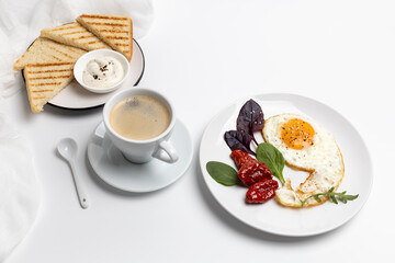 Fried egg on the plate, toasts and a cup of coffee.